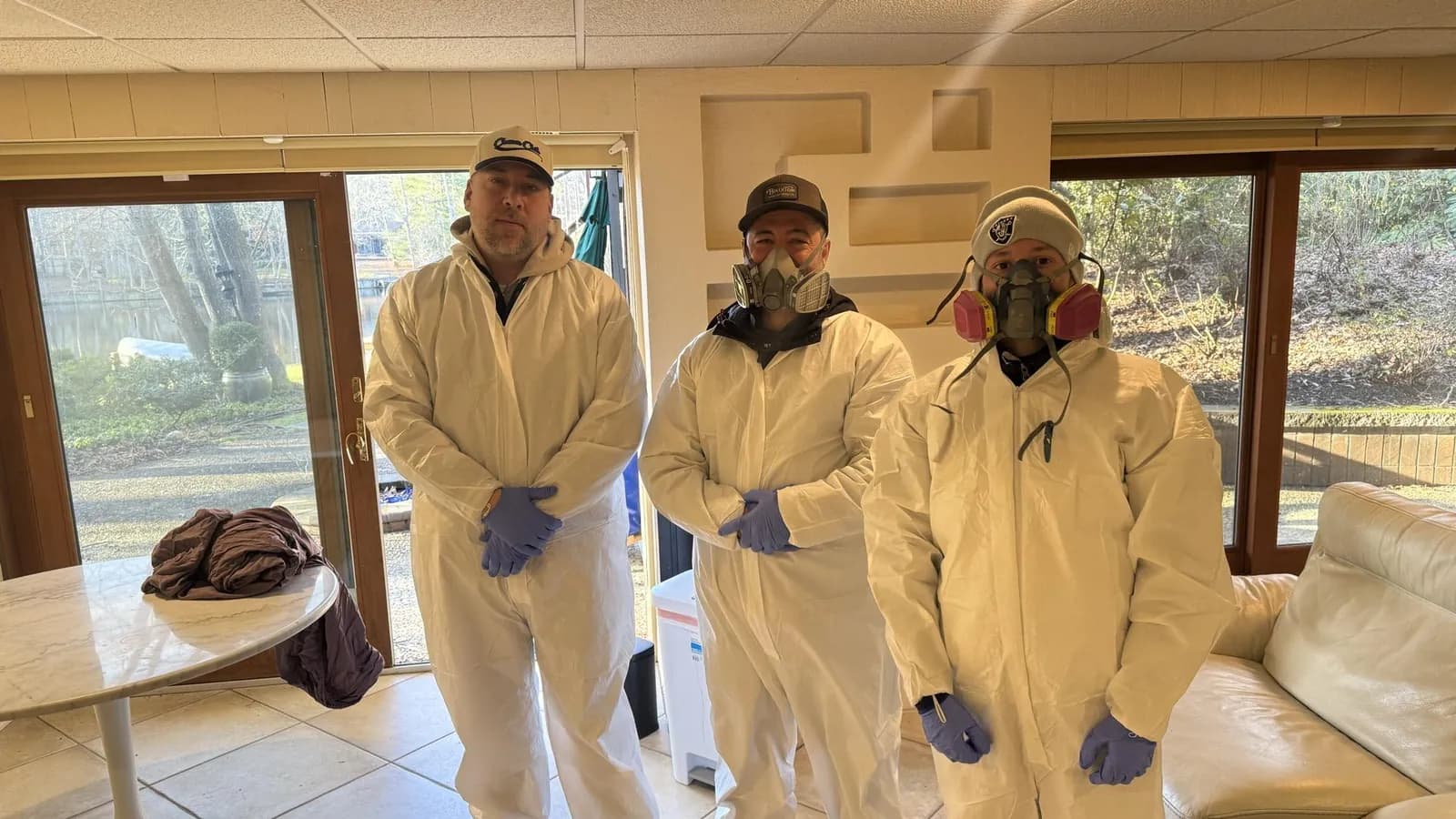 Three Summit technicians in protective suits and respirators on a job site