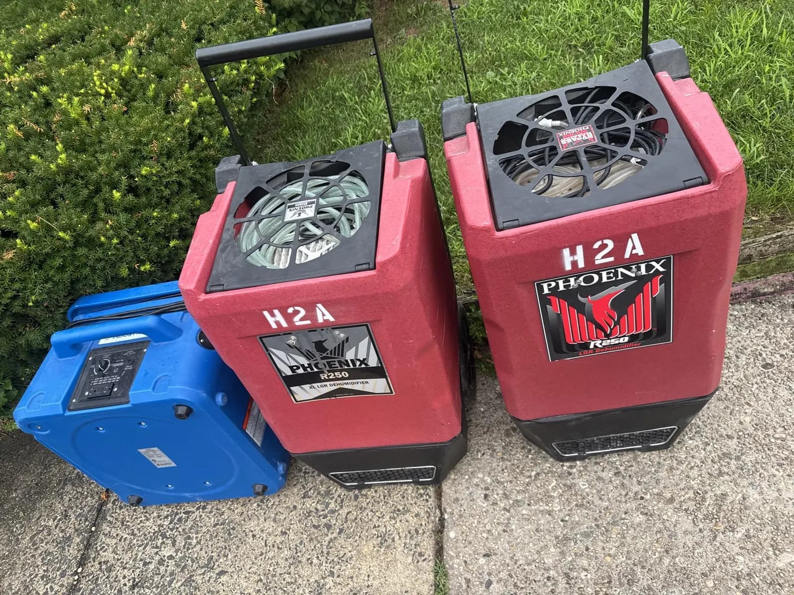 Commercial dehumidifiers staged outside a property for structural drying